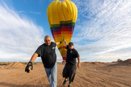 Rainbow Ryders crew preparing hot air balloon for liftoff.
