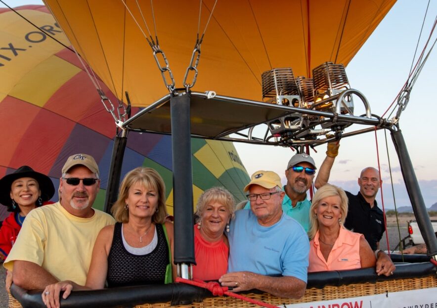group of adults posing in a hot air balloon