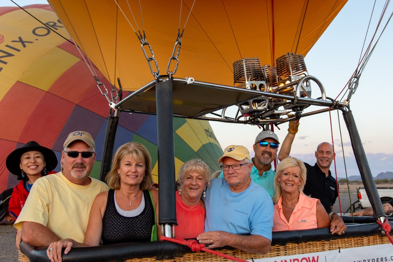 group of adults posing in a hot air balloon