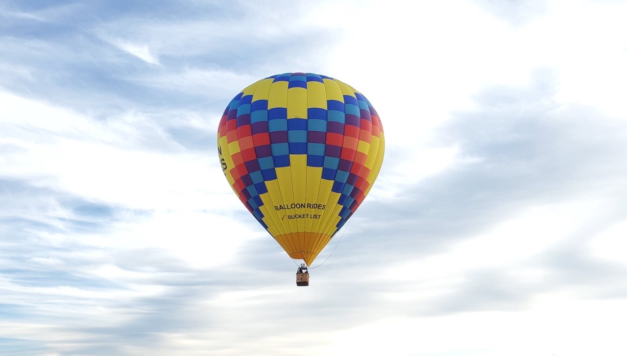 Hot air balloon with partially cloudy sky in background