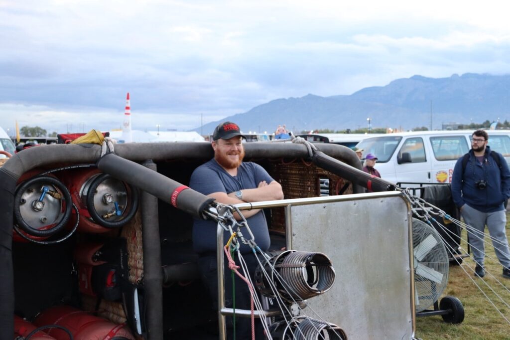 Pilot standing next to hot air balloon basket