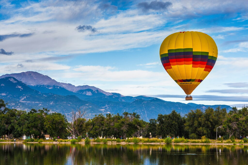 Low flying hot air balloon over body of water