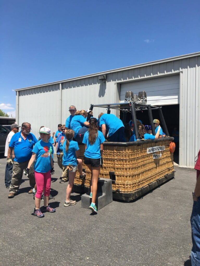 Passengers practice getting into a hot air balloon basket