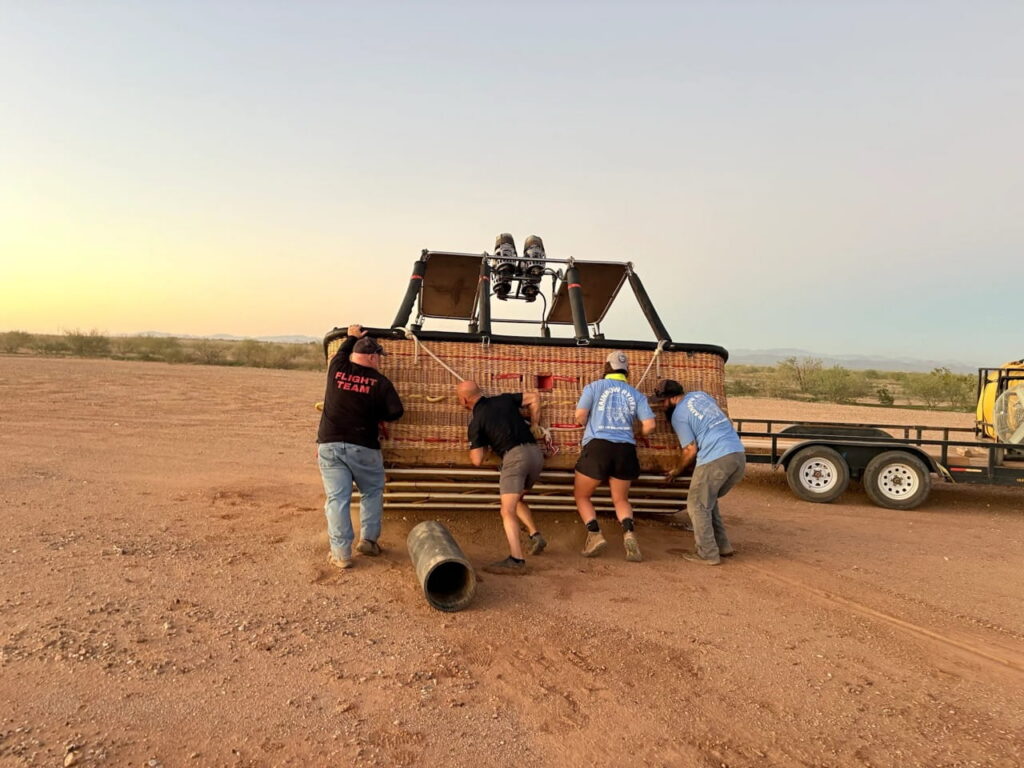 Rainbow Ryders staff flipping a balloon basket onto its side